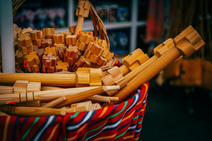Basket of wooden kitchen mallets on a colorful cloth.