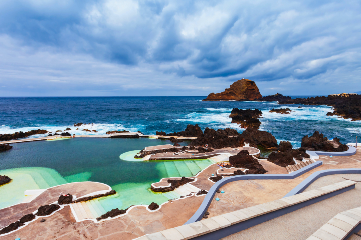 Coastal pool with rocky shoreline and cloudy sky in the background.